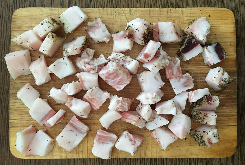 Guanciale cut into pieces on a board