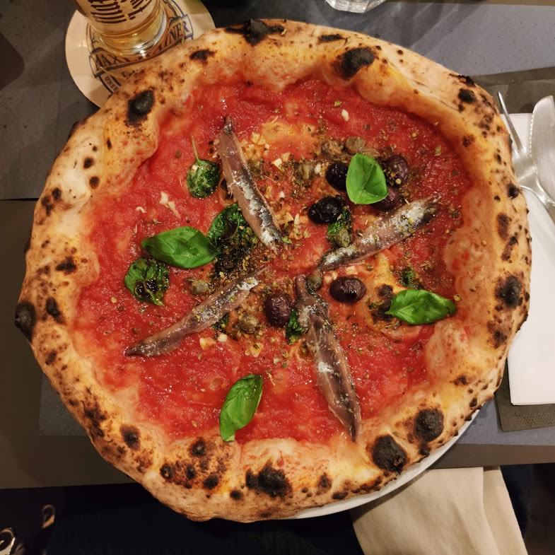 Een prachtige Napolitaanse pizza met Puttanesca topping