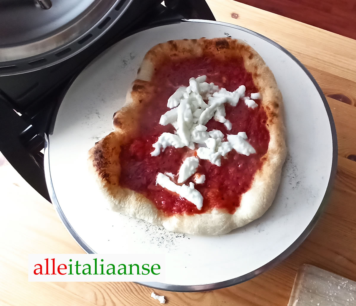 Mozzarella toevoegen op Italiaanse pizza - met een elektrische pizzaoven gebakken