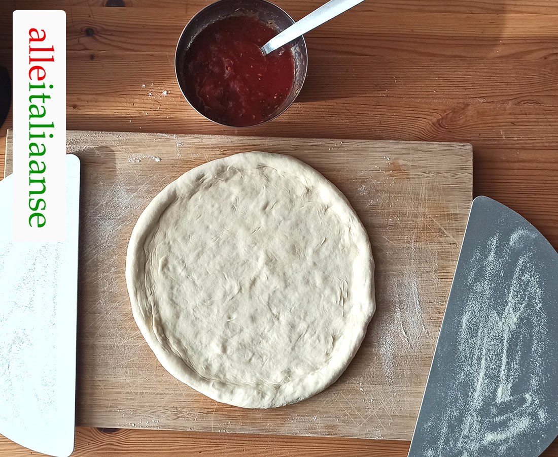 Een pizzaschep, bestrooid met harde tarwe griesmeel, om pizza in de oven te doen