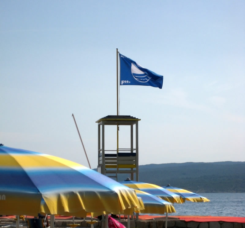 Een strand met de blauwe vlag